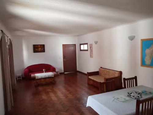 a living room with a red couch and a table at Herifanja appart et Salama appart in Antsirabe