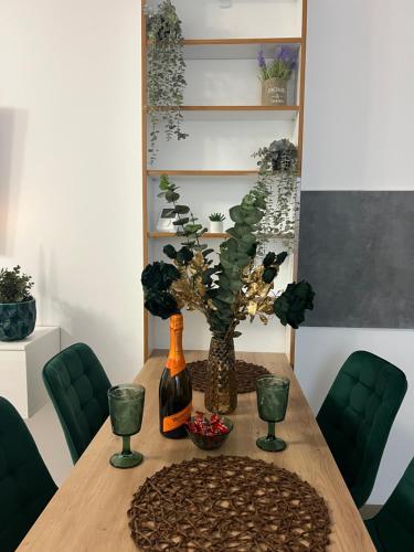 una mesa de comedor con un jarrón con una planta en Emerald Residence, en Brasov