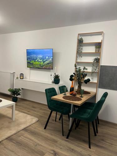 Un comedor con una mesa y sillas verdes. en Emerald Residence, en Brasov