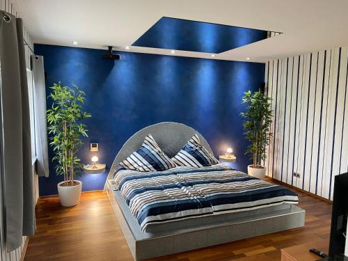 a bed in a room with a blue wall at HTS Haus Respirada Wellnessarea, Whirlpool, GYM, Sauna in Meckenheim