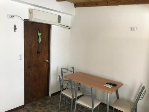 Habitación con mesa, sillas y puerta en Portofino 43, en Santa Clara del Mar