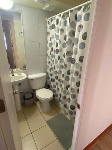 un bagno con un water e una tenda da doccia di Arriendo Departamento a Coquimbo