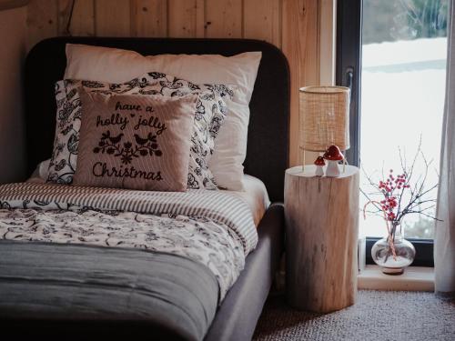 a bed with a pillow that says have a naughtylyolly christmas at Owczarnia Tatry in Bukowina Tatrzańska