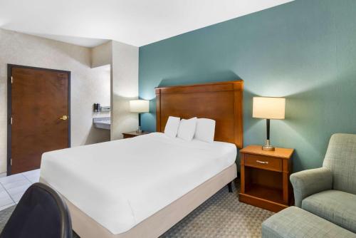a hotel room with a bed and a chair at Sonesta Essential Houston Hobby Airport in Houston
