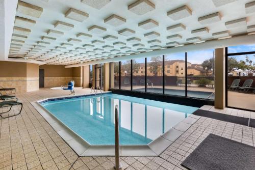 a pool in a building with a large amount of windows at Sonesta Essential Houston Hobby Airport in Houston