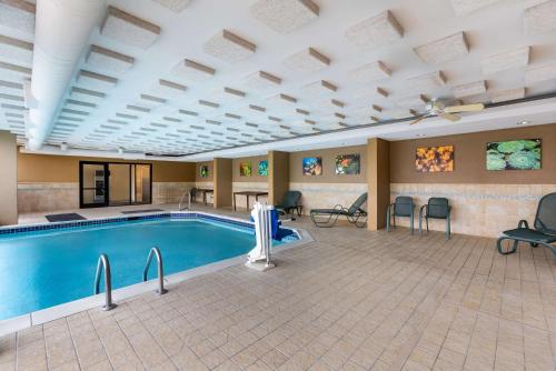 a pool in a hotel room with chairs around it at Sonesta Essential Houston Hobby Airport in Houston