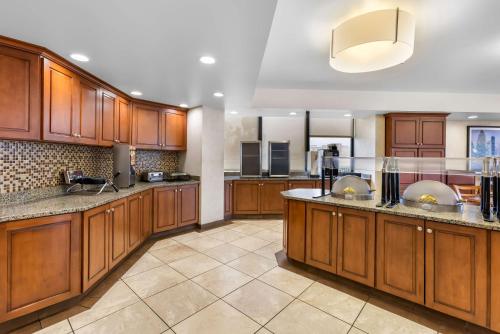 a large kitchen with wooden cabinets and counters at Sonesta Essential Houston Hobby Airport in Houston