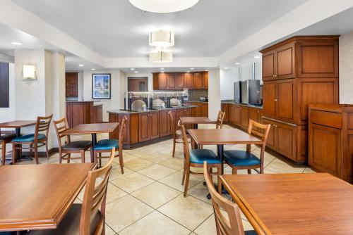 a kitchen and dining room with wooden tables and chairs at Sonesta Essential Houston Hobby Airport in Houston