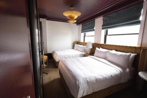 a hotel room with two beds and a window at Fidelity Hotel in Cleveland