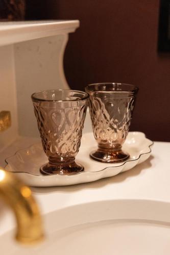 two glass cups sitting on a plate on a sink at Fidelity Hotel in Cleveland
