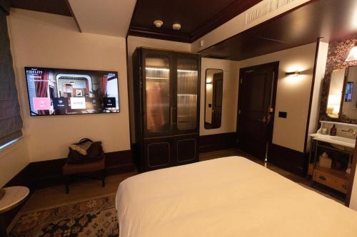 a bedroom with a bed and a tv and a bathroom at Fidelity Hotel in Cleveland