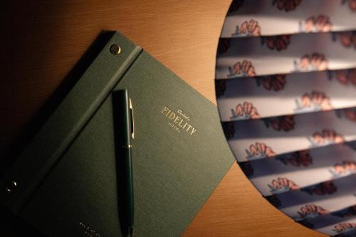 a green book sitting on top of a table at Fidelity Hotel in Cleveland