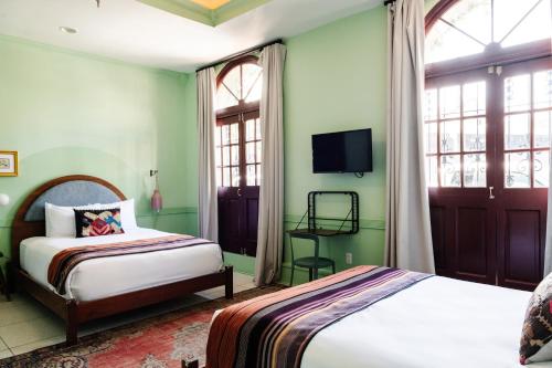 une chambre avec un lit et une télévision au mur dans l'établissement The Frenchmen New Orleans by Kasa Living, à La Nouvelle-Orléans