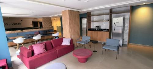 un salon avec un canapé rouge et une cuisine dans l'établissement Studio Aconchegante para 2 pessoas, à São Paulo
