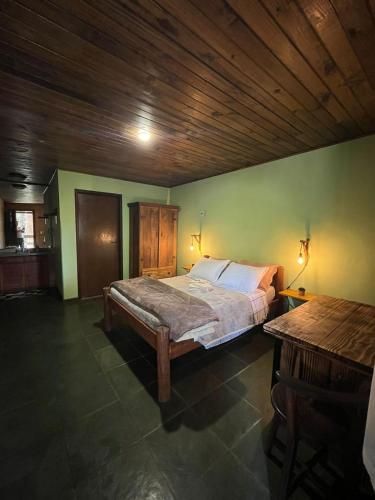 a bedroom with a bed and a wooden ceiling at Recanto dos Sonhos Guest House in Lumiar