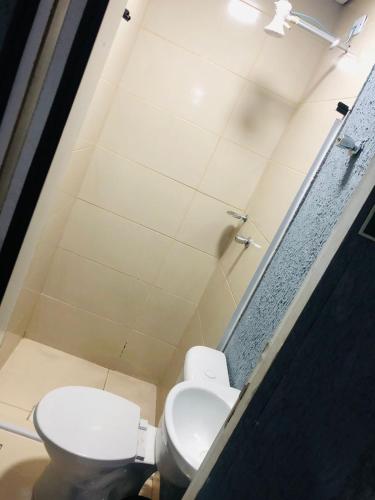 a bathroom with a toilet and a sink at FIRMH HOSTEL Café da manhã in Guarulhos