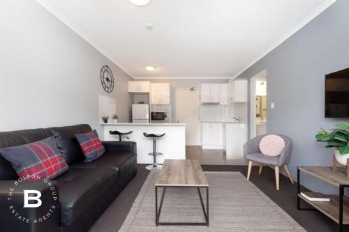 a living room with a black couch and a table at City Skyline View, Urban Retreat in Brisbane