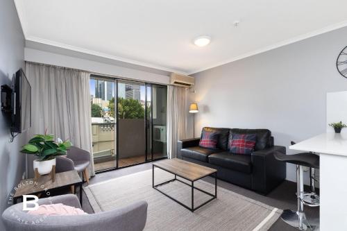 a living room with a couch and a table at City Skyline View, Urban Retreat in Brisbane