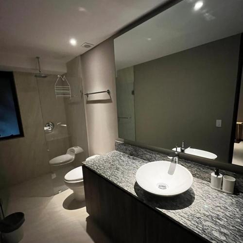 a bathroom with a sink and a toilet and a mirror at Acapulco Diamante La Isla Residences & Spa in Acapulco