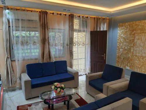 a living room with blue couches and a table at Paradis Tranquille Douala, Yassa in Ngori
