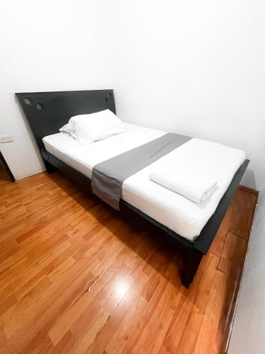 a bed with white sheets on a wooden floor at Hotel Yellow Maraya, Pereira in Pereira