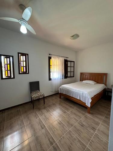 米格尔-佩雷拉Hostel Ares do Mundo的一间卧室配有一张床、风扇和椅子