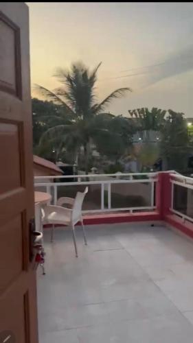 a view of a balcony with a chair and palm trees at Paradise Estate in Gambia in Old Yundum