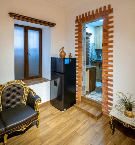 a living room with a black refrigerator and a chair at Heart of Tbilisi in Tbilisi City