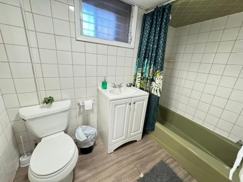 ein Badezimmer mit Toilette und Waschbecken und einem Fenster in der Unterkunft Cozy 1 bedroom close to NYC with private bar in North Bergen