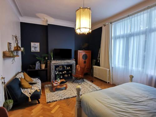 a bedroom with a bed and a living room at Maison d'hôtes de Xavier in Brussels