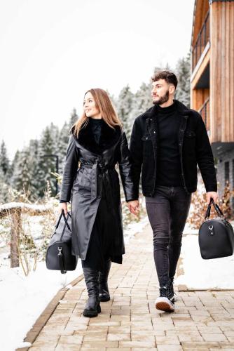a man and woman walking down a street holding hands at TRI VODY Demänovská Dolina in Liptovský Mikuláš