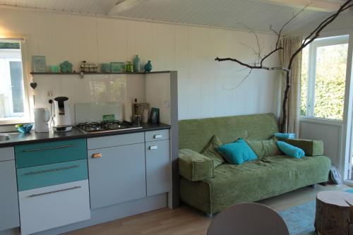 een woonkamer met een bank en een keuken bij Beachhouse Rockanje in Rockanje