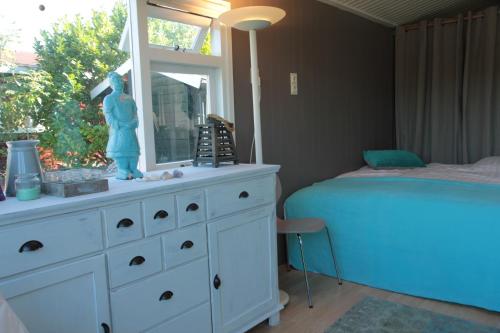 een slaapkamer met een bed en een dressoir met een spiegel bij Beachhouse Rockanje in Rockanje