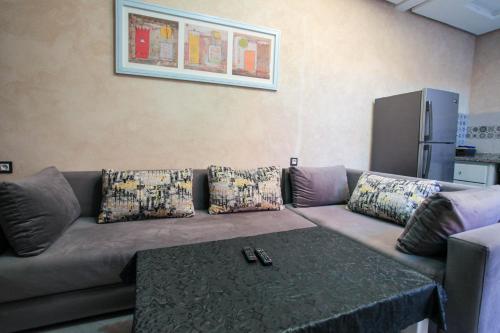 a living room with a couch with pillows and a table at Dar Simane Aftas in Mirleft