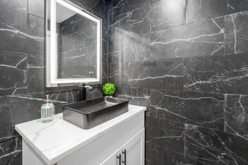 a black bathroom with a sink and a mirror at Fully Equipped 1BR with King Bed, Pool & Free Parking in Houston