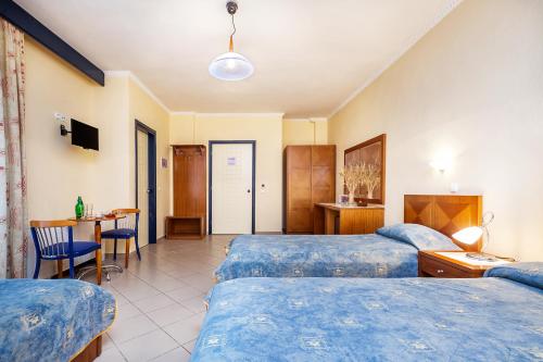 a hotel room with two beds and a table at Atrium Hotel in Pefkohori
