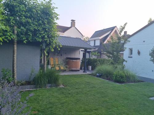 a backyard of a house with a grass yard at JaNa in Kaatsheuvel