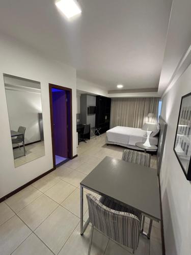 a hotel room with a bed and a table and chairs at Loft Celita Franca in Feira de Santana