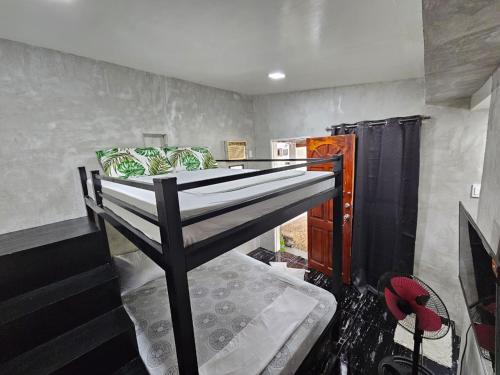 a bedroom with a bunk bed in a room at Acacia Sunset Village Inn in Dauis