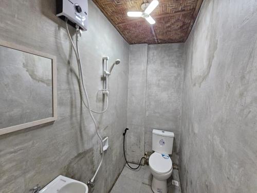 a bathroom with a shower with a toilet and a sink at Acacia Sunset Village Inn in Dauis
