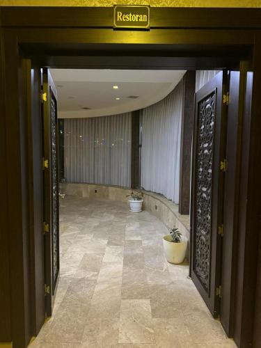 a hallway with two potted plants in a building at Black Mont İnn Hotel in Baku