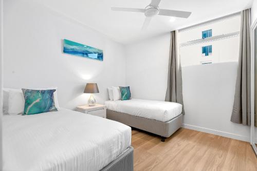 a bedroom with two beds and a window at Bokarina Beach Apartments, an Ascend Collection Hotel in Bokarina
