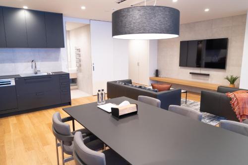 a kitchen and living room with a table and chairs at Wadano Gateway Suites & Apartments in Hakuba