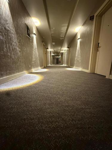 an empty hallway of a building with lights on the floor at Black Mont İnn Hotel in Baku