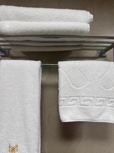 a group of white towels on a towel rack at Black Mont İnn Hotel in Baku