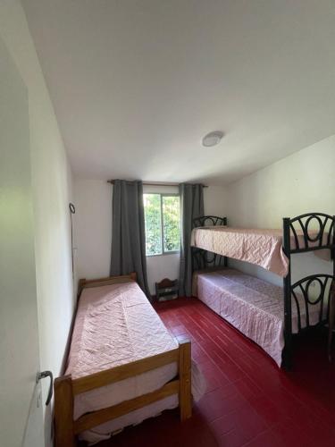 a bedroom with two bunk beds and a window at Casa a 1 cuadra del Río San Antonio in San Antonio de Arredondo