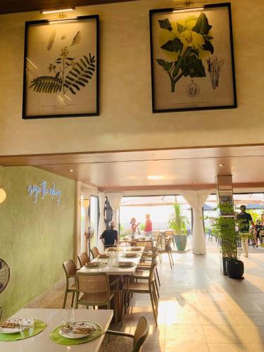 a restaurant with tables and chairs and people in it at Natalna Boutique Home in Bacnotan