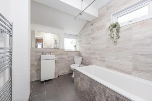 ein Badezimmer mit Badewanne, Toilette und Waschbecken in der Unterkunft Medway, Rochester Stays Living - Contractors, Family, Free Parking, Garden, Sleeps up to 6 guests in Wainscot