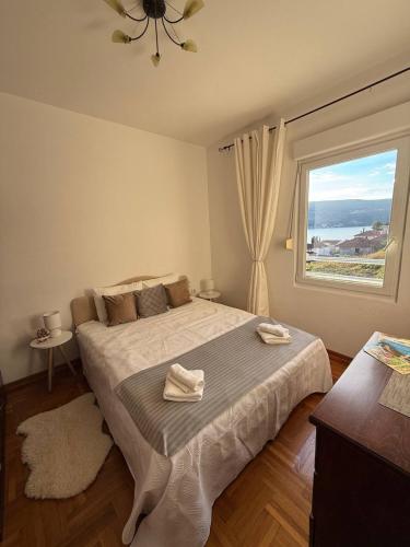 een slaapkamer met een groot bed met een groot raam bij Savina apartment Herceg Novi in Herceg-Novi
