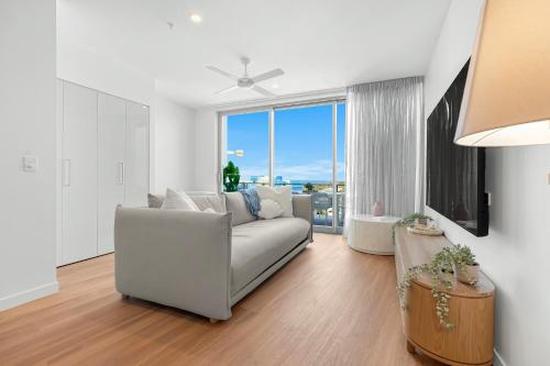 a living room with a couch and a large window at Bokarina Beach Apartments, an Ascend Collection Hotel in Bokarina